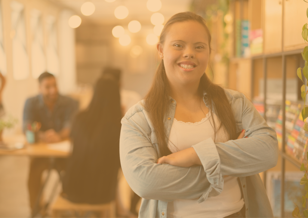 Mulher sorrindo com blusa branca e jaqueta num filtro amarelado.