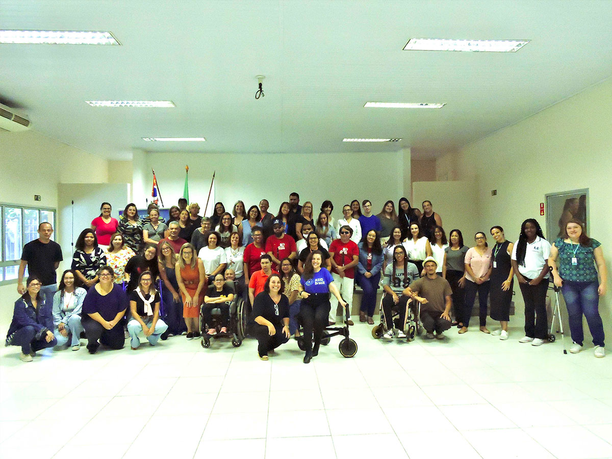 Multidão de pessoas participantes do projeto ASAS em formação de time de futebol.