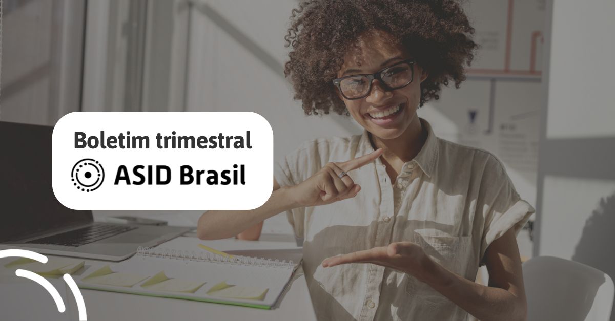 Mulher negra com uma camisa branca com a frase "boletim trimestral ASID Brasil".